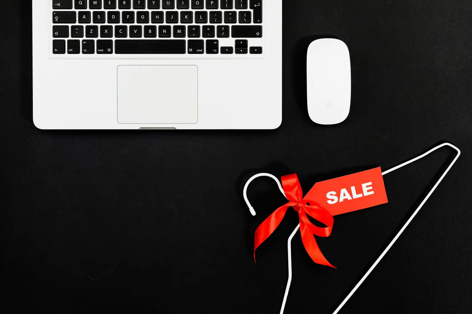 Laptop computer next to a discount sale sign, illustrating an online software subscription promo code
